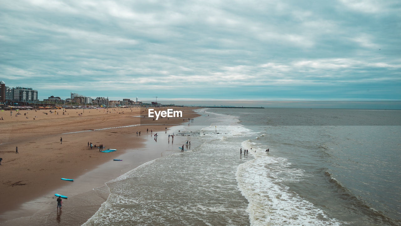 group of people at beach against sky