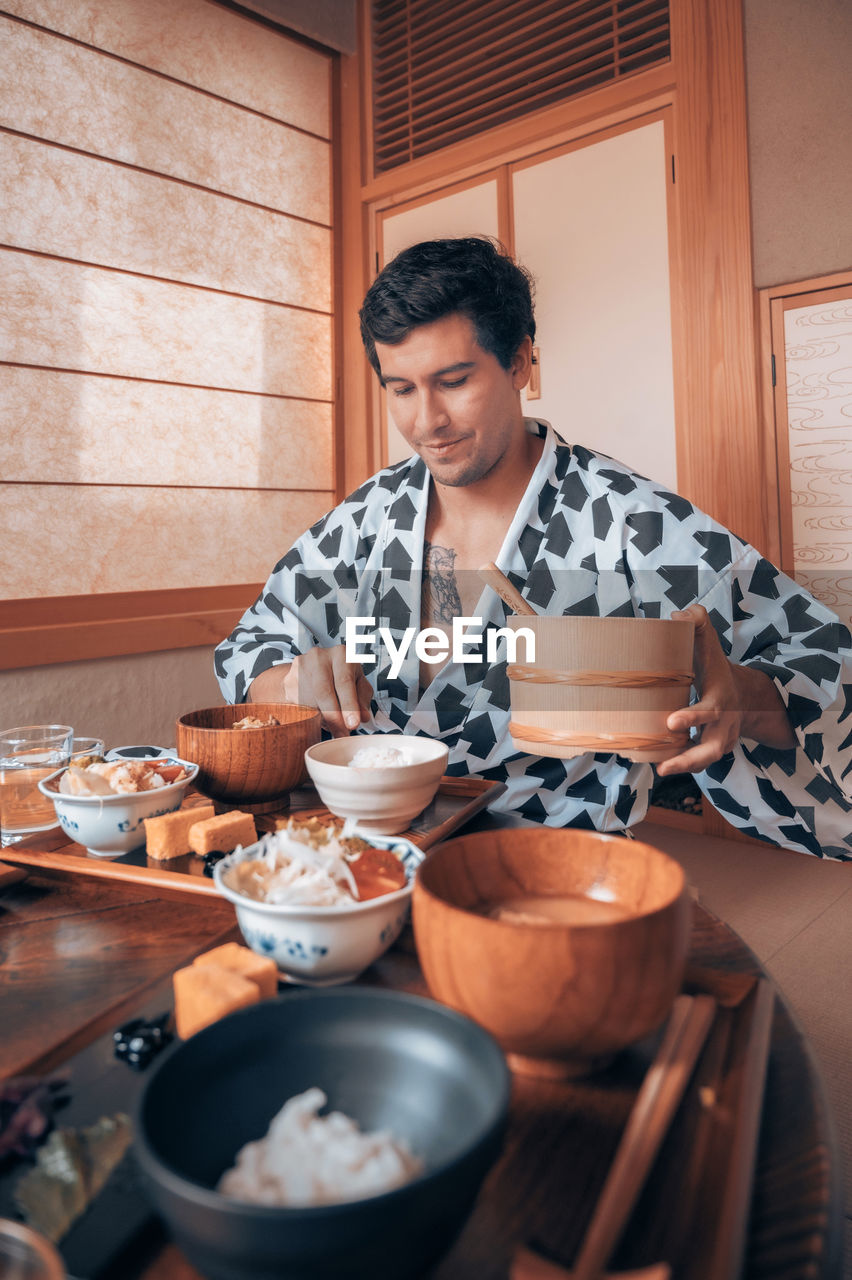 Young man preparing food at home in japan