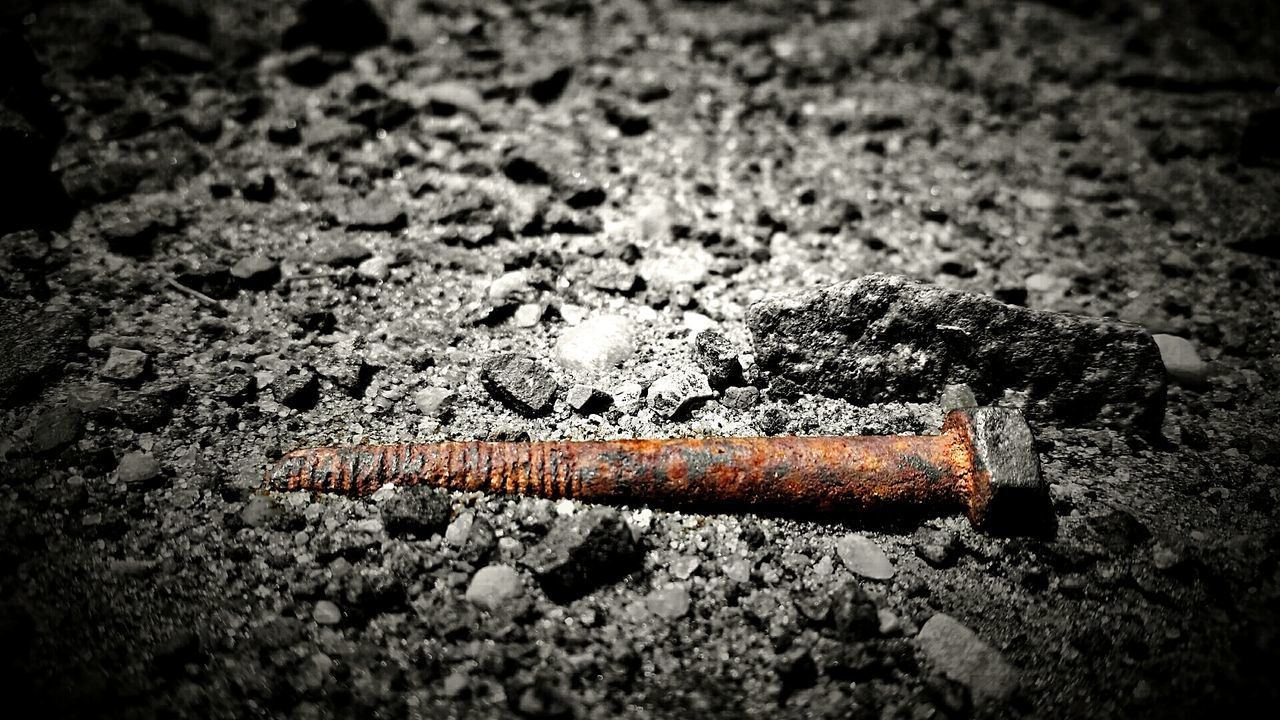 Close-up of rusty nail on street