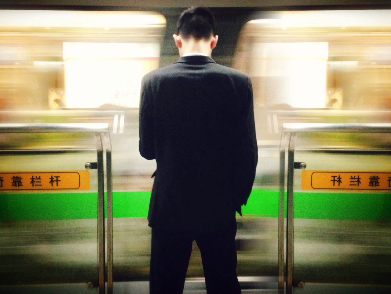 Rear view of man standing on railroad station platform