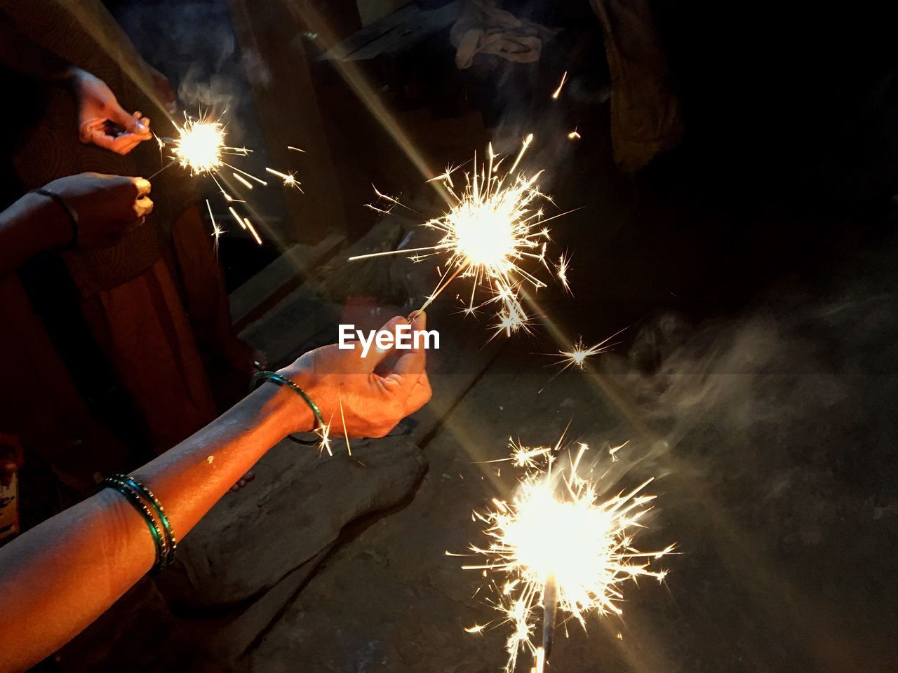 LOW ANGLE VIEW OF FIREWORK DISPLAY AT NIGHT DURING SUNSET