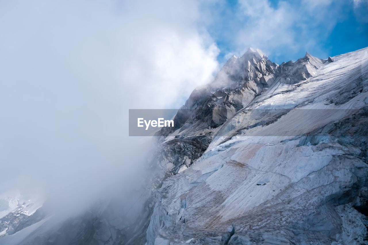 low angle view of snowcapped mountains against sky