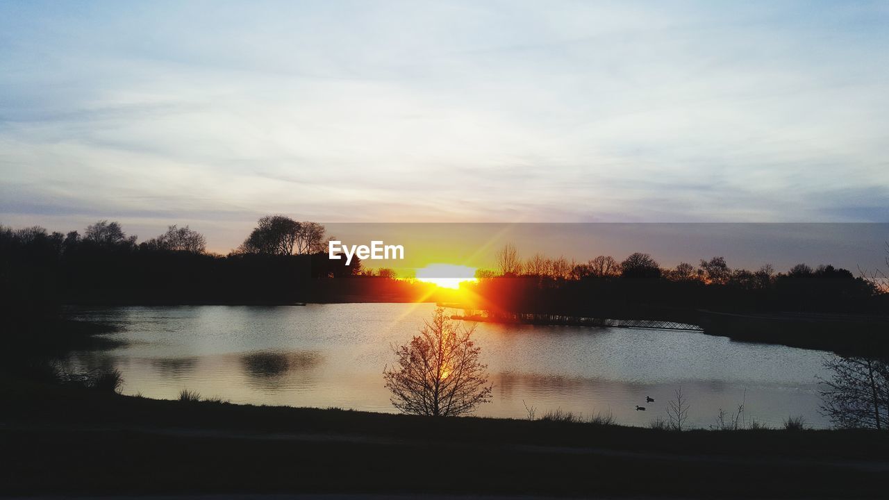 SCENIC VIEW OF LAKE AGAINST SUNSET SKY