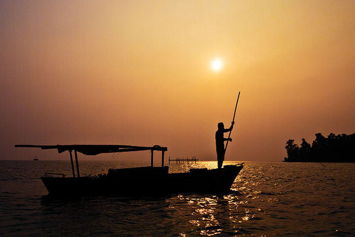 SILHOUETTE OF PEOPLE IN SEA AT SUNSET