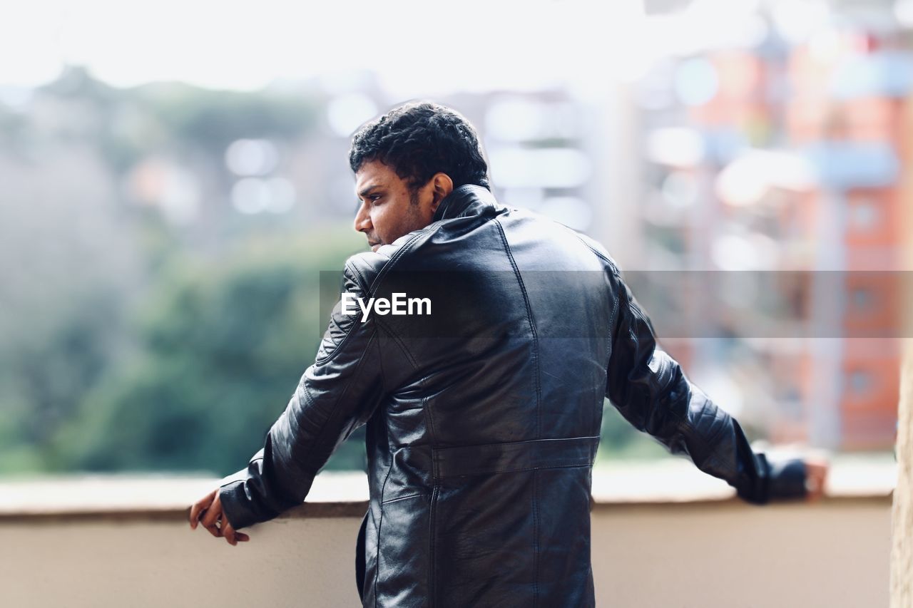 Side view of young man looking away outdoors