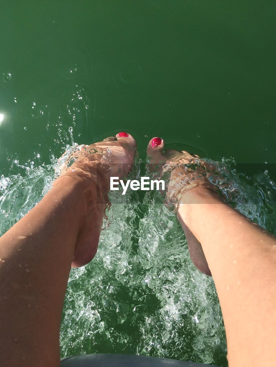 Low section of woman feet in water