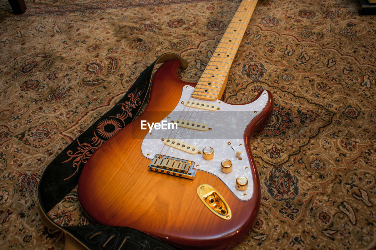 CLOSE-UP OF GUITAR ON PIANO