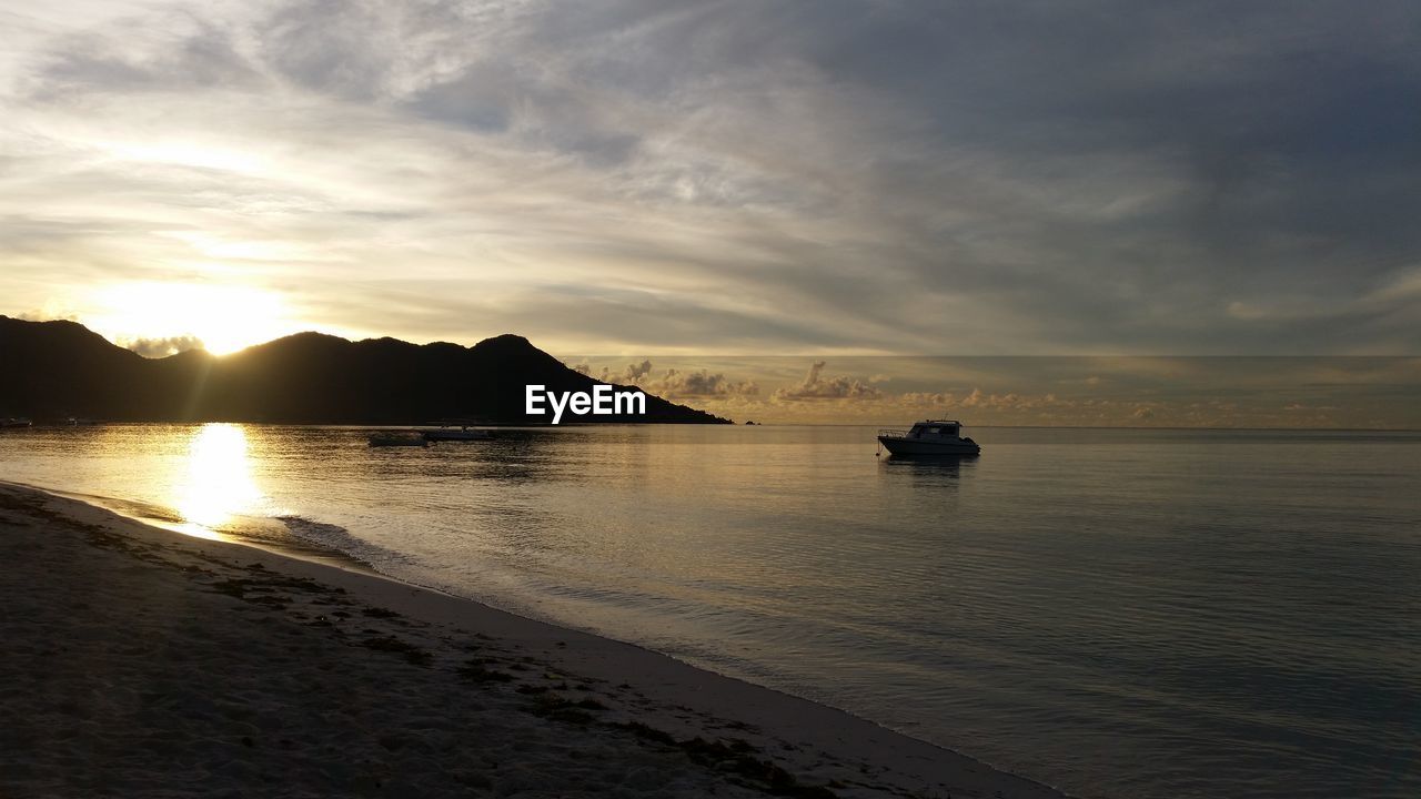 SILHOUETTE BOATS IN SEA AGAINST SKY DURING SUNSET