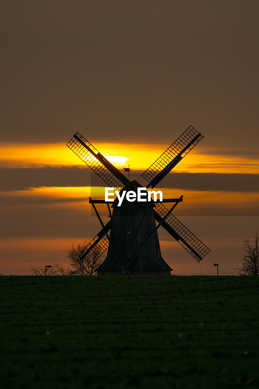 TRADITIONAL WINDMILL ON FIELD DURING SUNSET