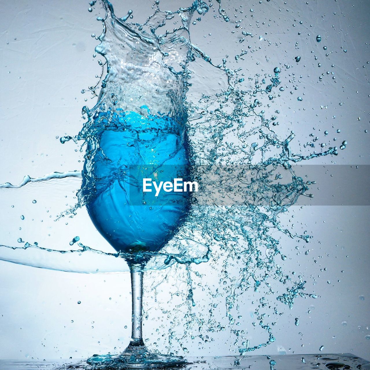 Close-up of water splashing against glass of wine