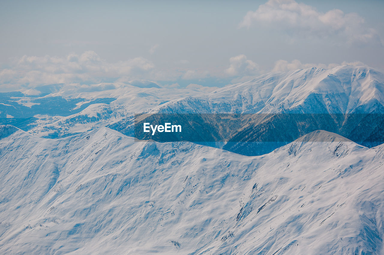 AERIAL VIEW OF SNOWCAPPED MOUNTAIN AGAINST SKY