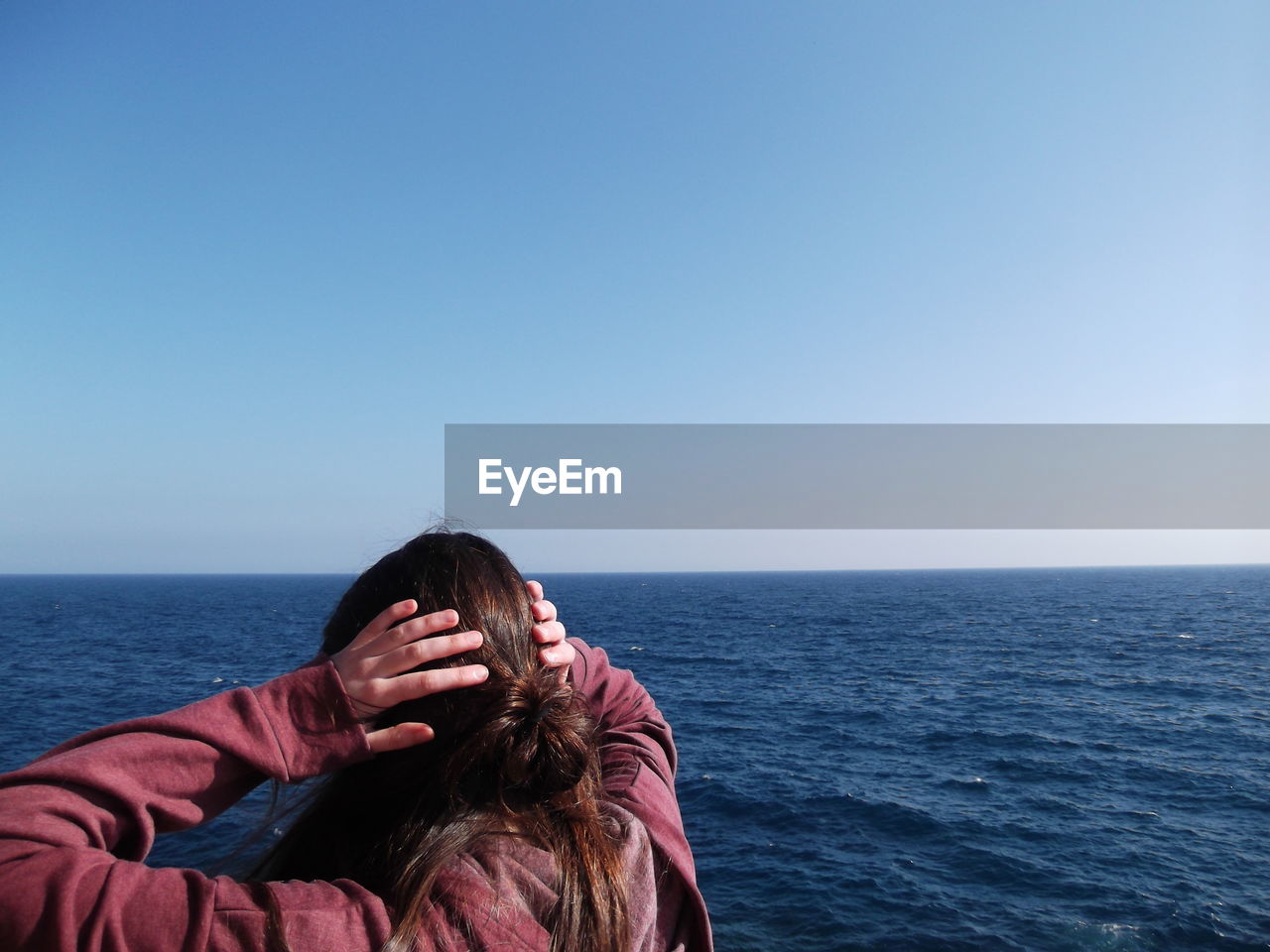 Woman in sea against clear sky