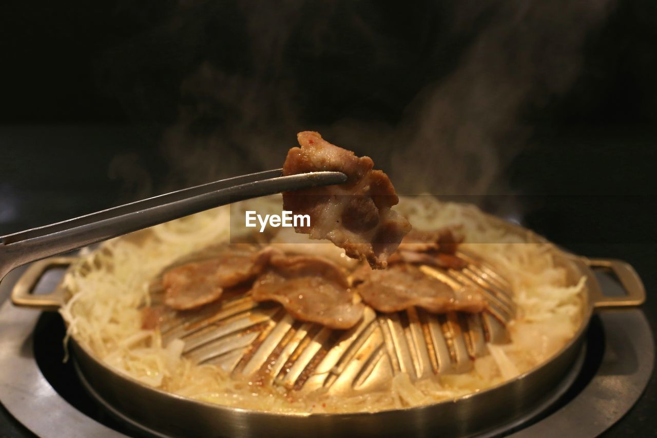 CLOSE-UP OF MEAT COOKING IN PAN