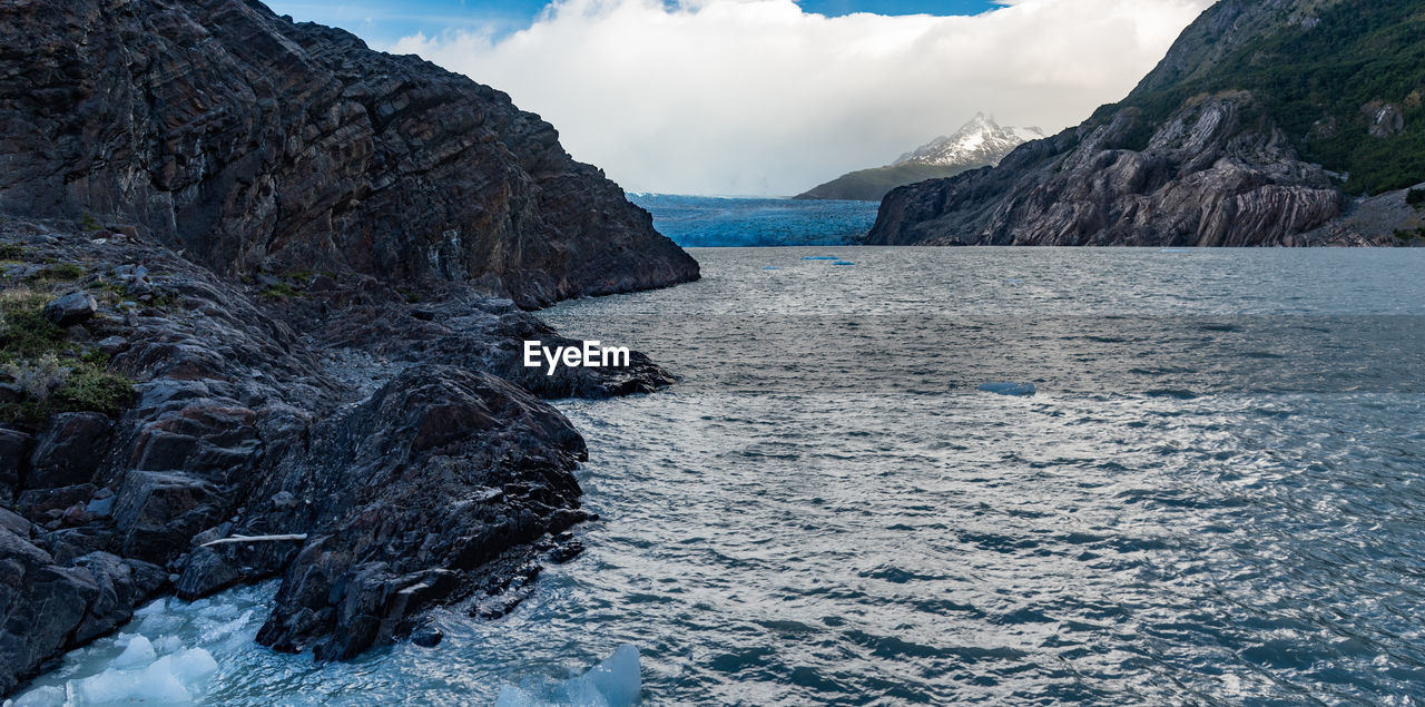 Scenic view of sea and mountains against sky