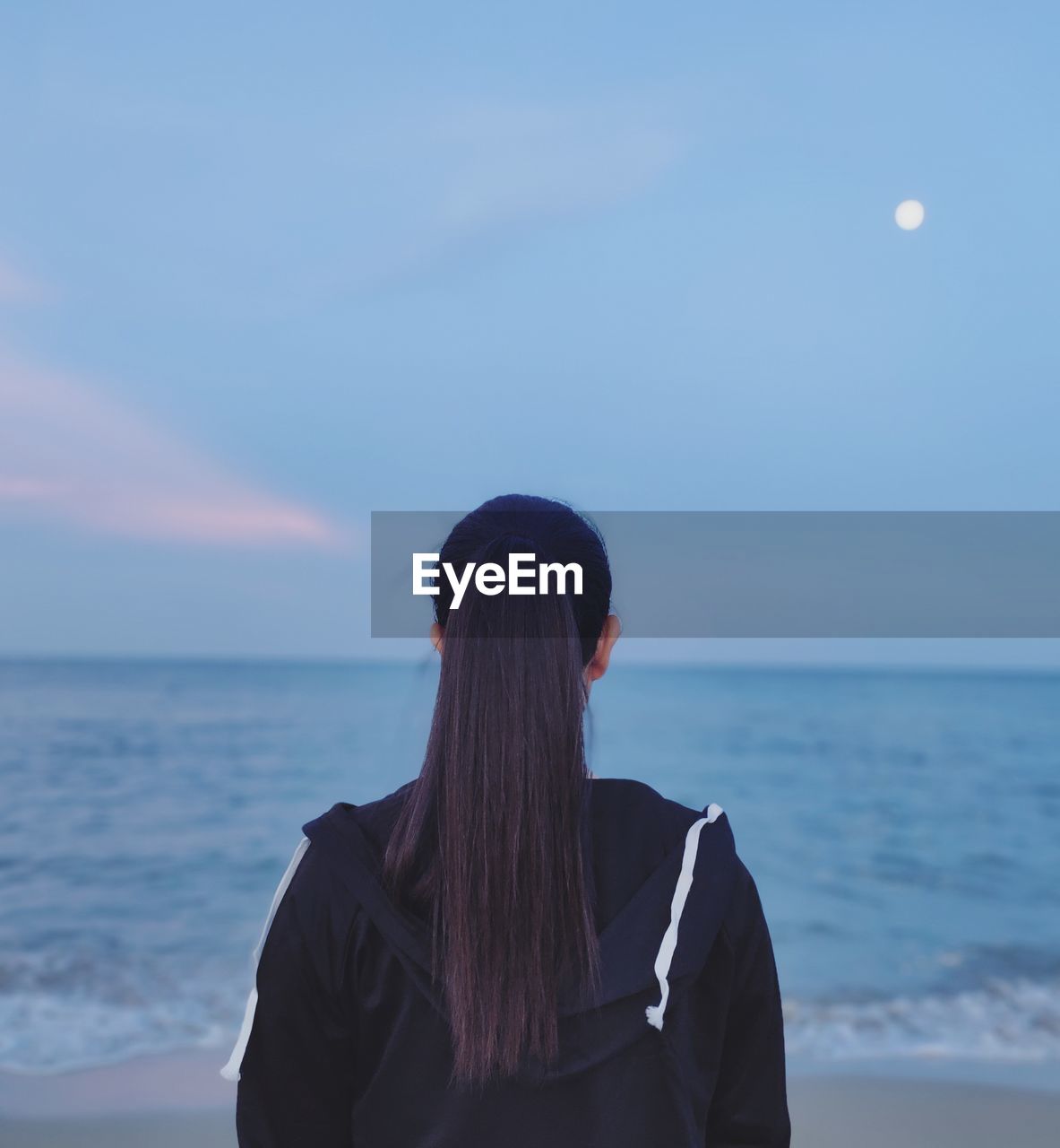 Rear view of woman looking at sea against sky