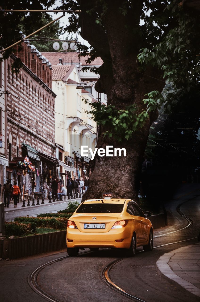 CARS ON STREET AGAINST BUILDINGS IN CITY