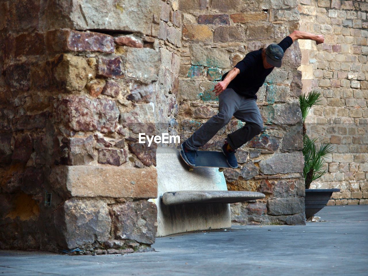 WOMAN JUMPING AGAINST BRICK WALL