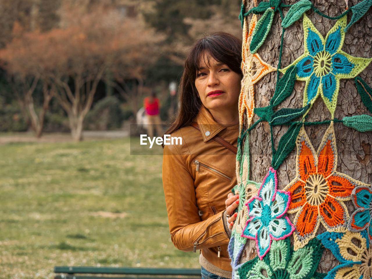 Portrait of young woman hugging a decorated tree