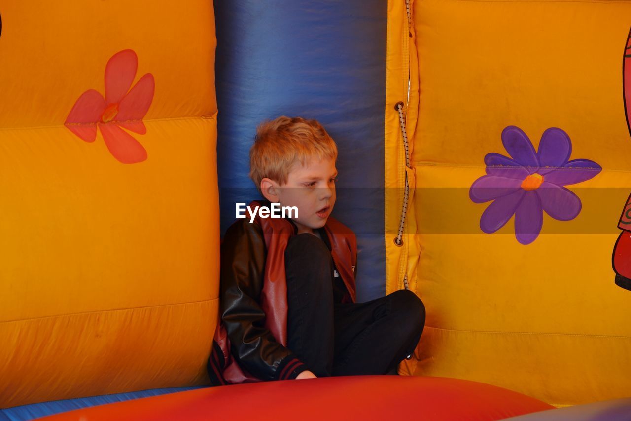 Boy sitting on colorful inflatable equipment