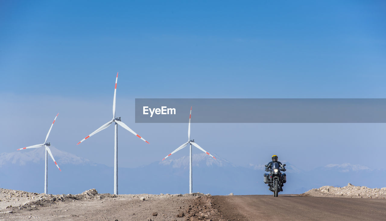 Man riding his adv motorbike at wind farm in the remote atacama desert