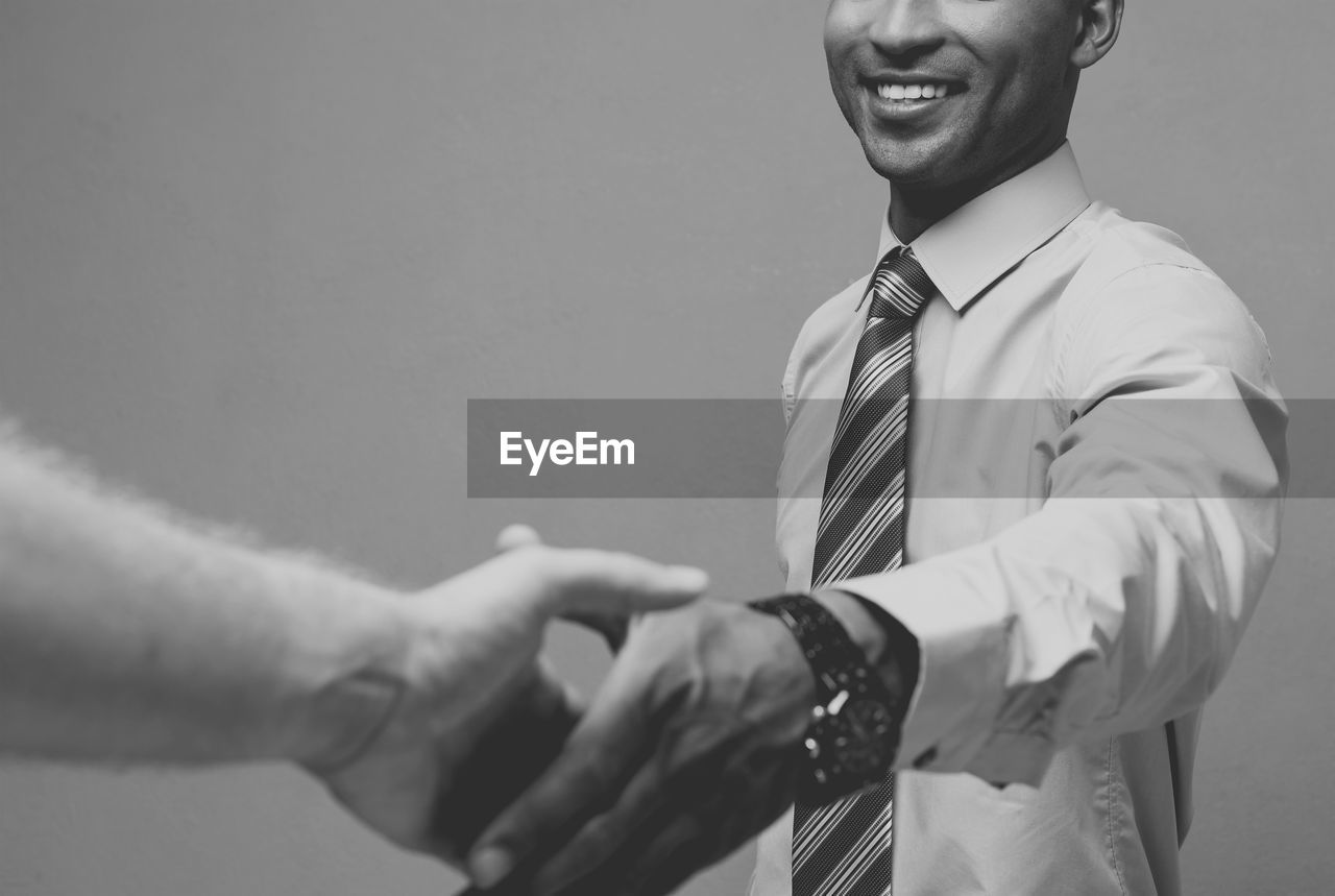 Midsection of businessman shaking hand