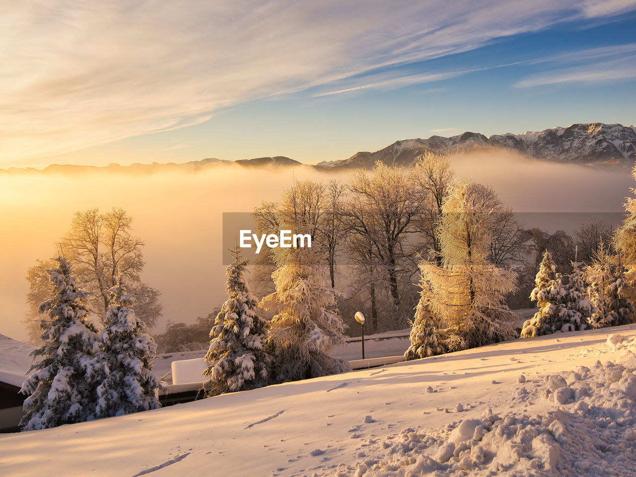 scenic view of snow covered landscape against sky during sunset