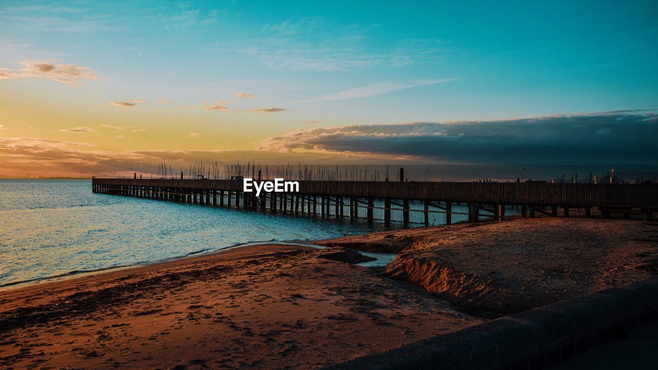 PIER ON SEA AGAINST SKY DURING SUNSET