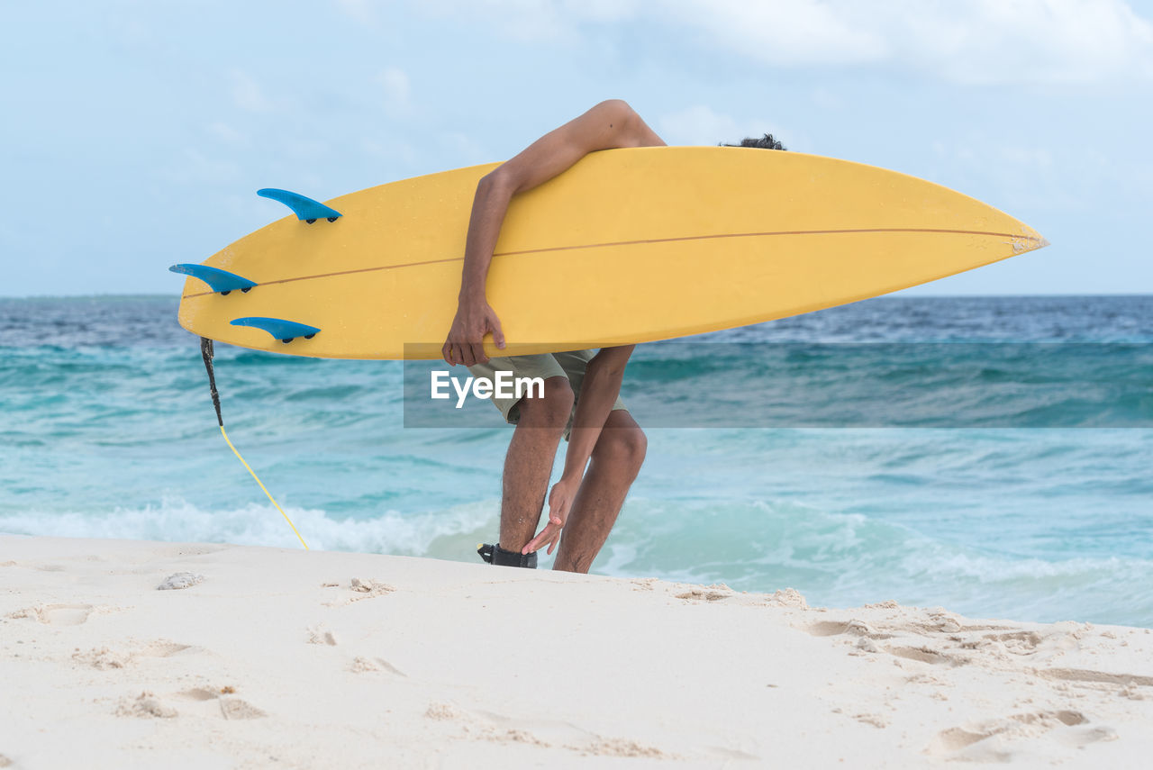 A young surfer holding a surfboard 