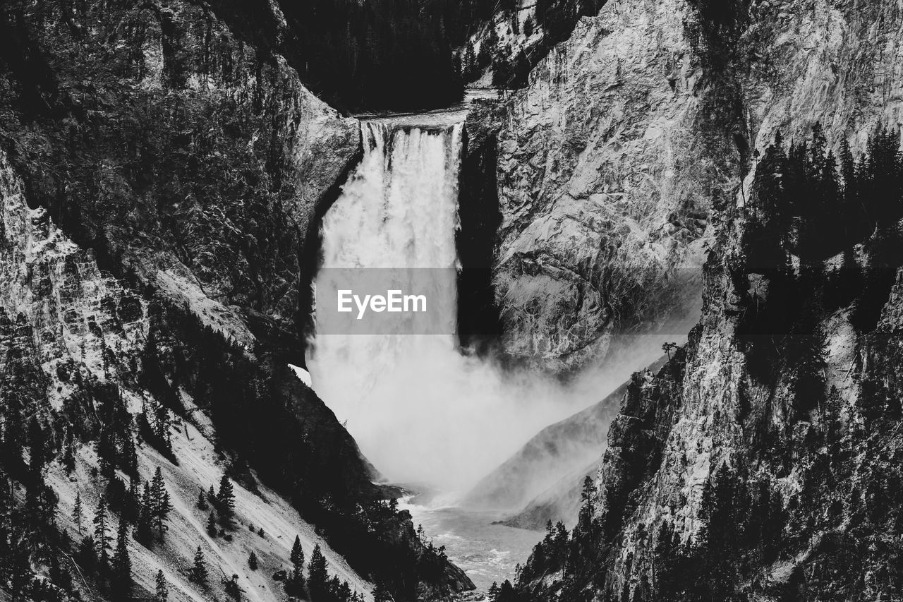 VIEW OF WATERFALL WITH MOUNTAIN IN BACKGROUND