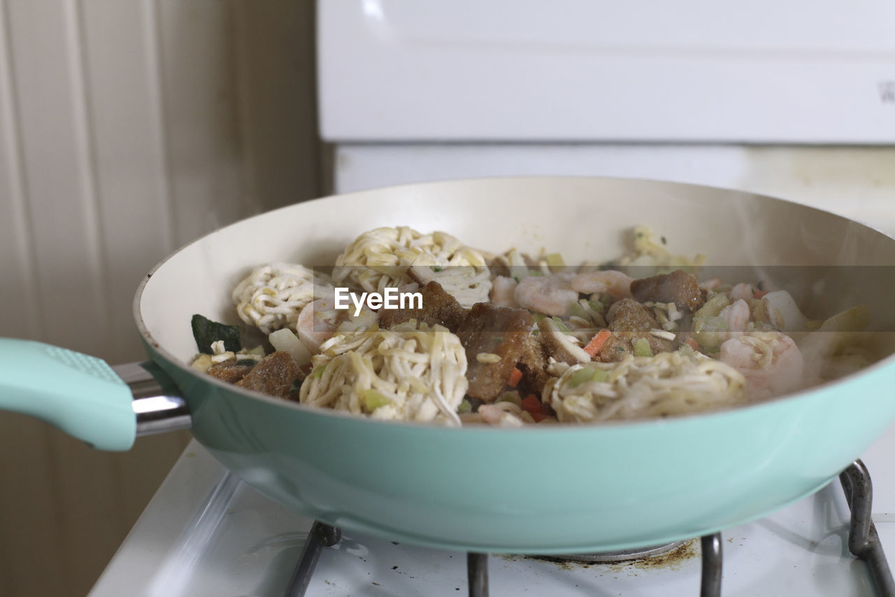 Close up of shrimp lo mein frying on a stove