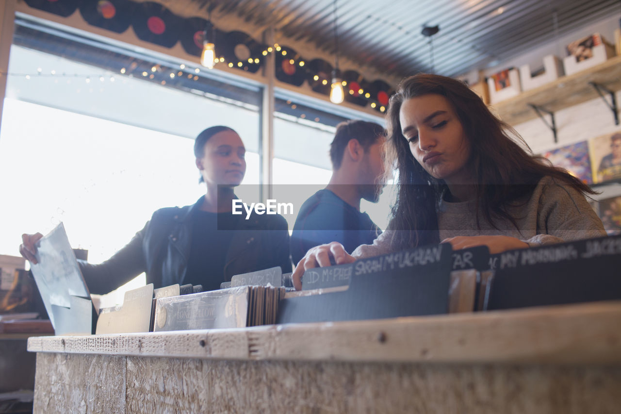 Three young adults in a record store.