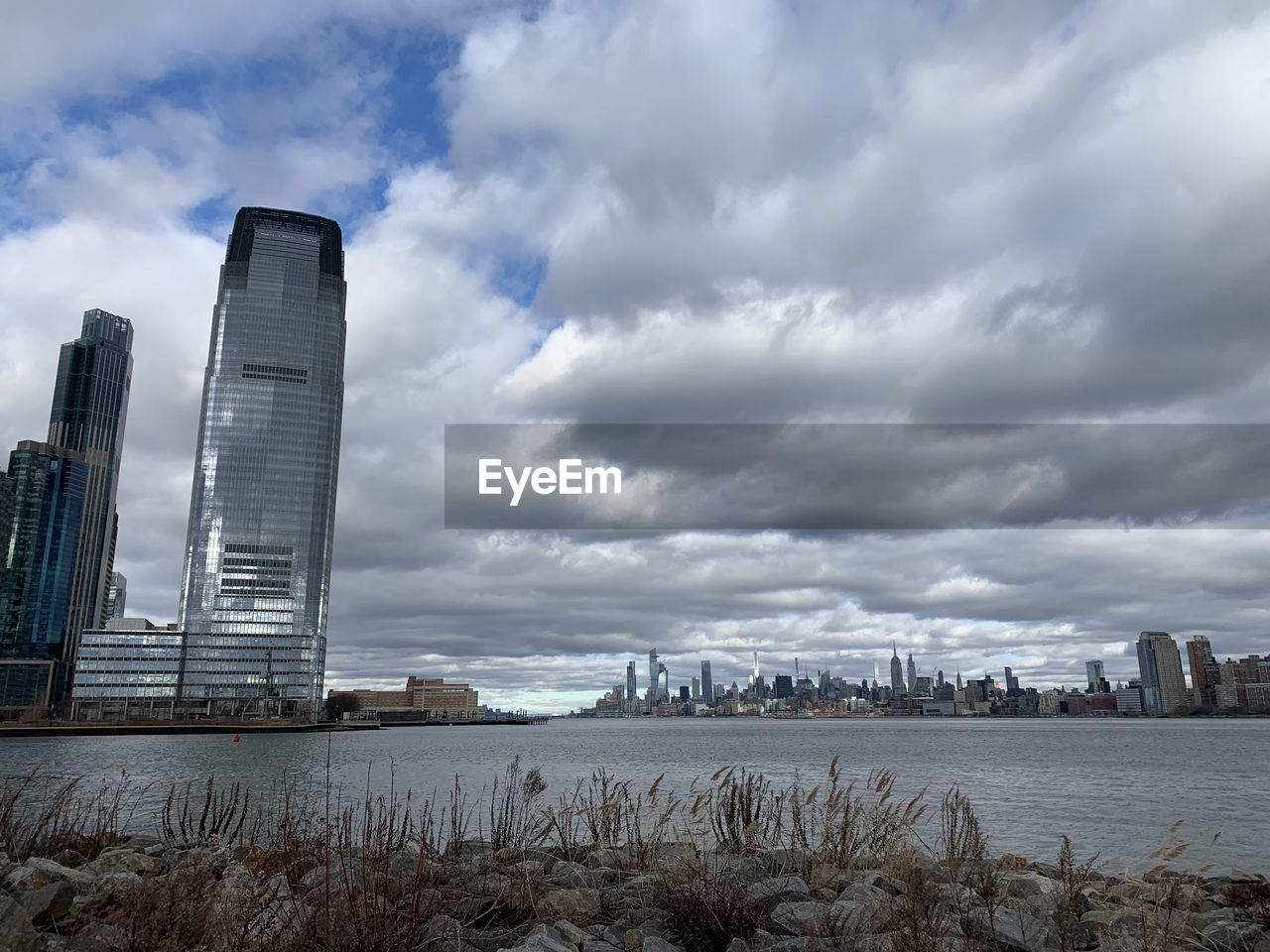 CITY BUILDINGS AGAINST CLOUDY SKY