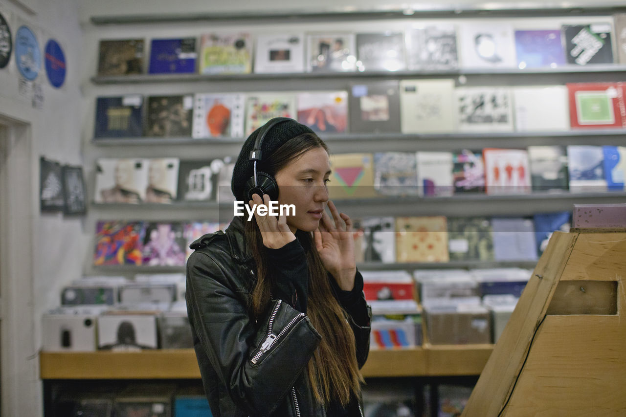 Young woman listening to music in a record store