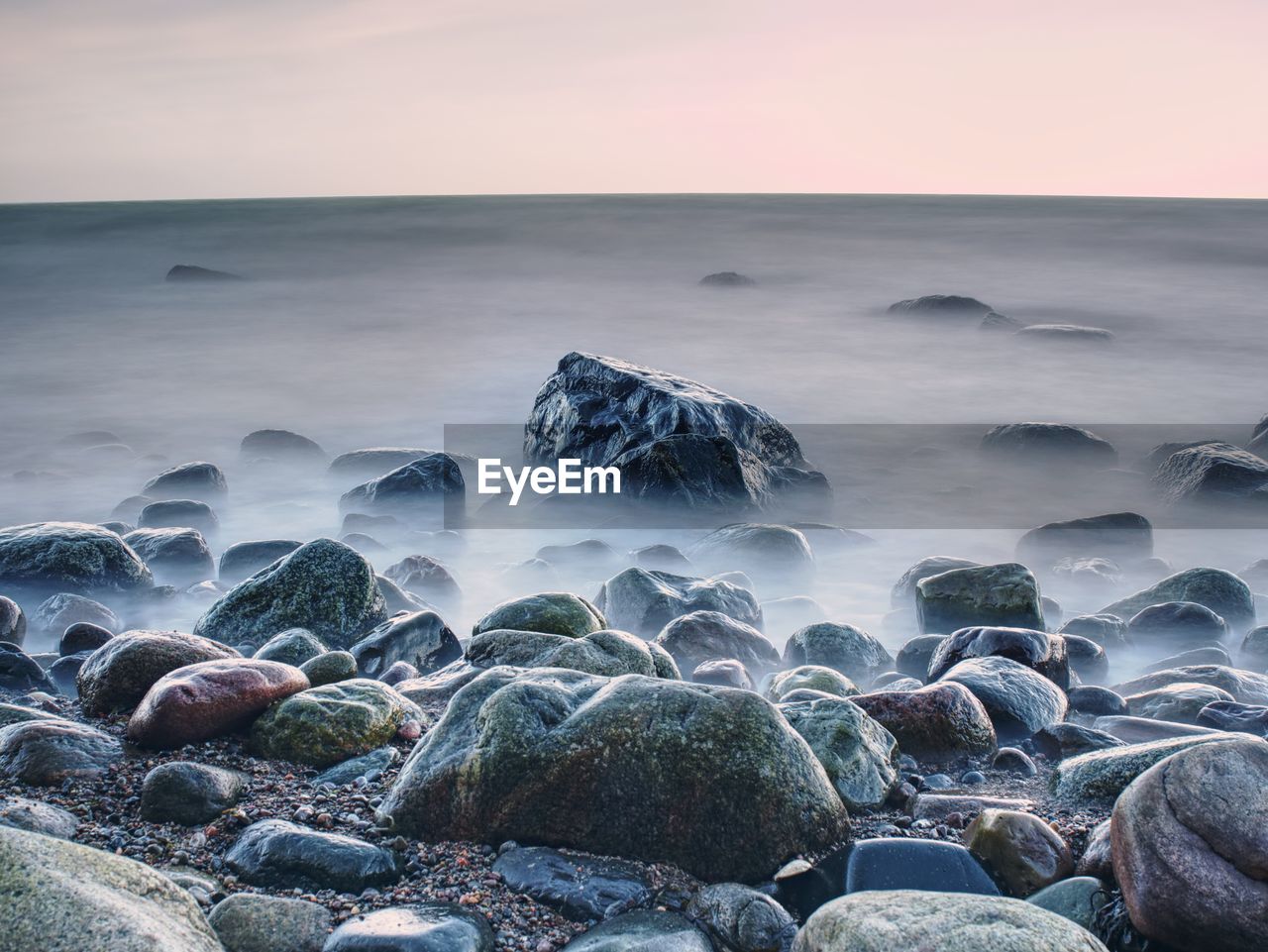 Beautiful seascape sea horizon and norwegian stone coastline, long exposure effect