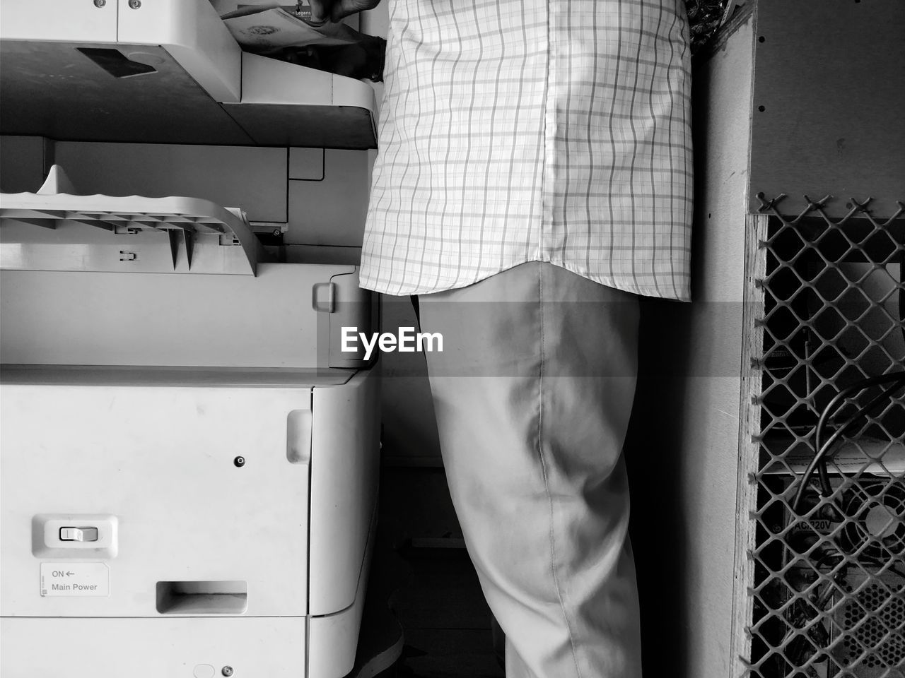 Midsection of man standing by photocopier