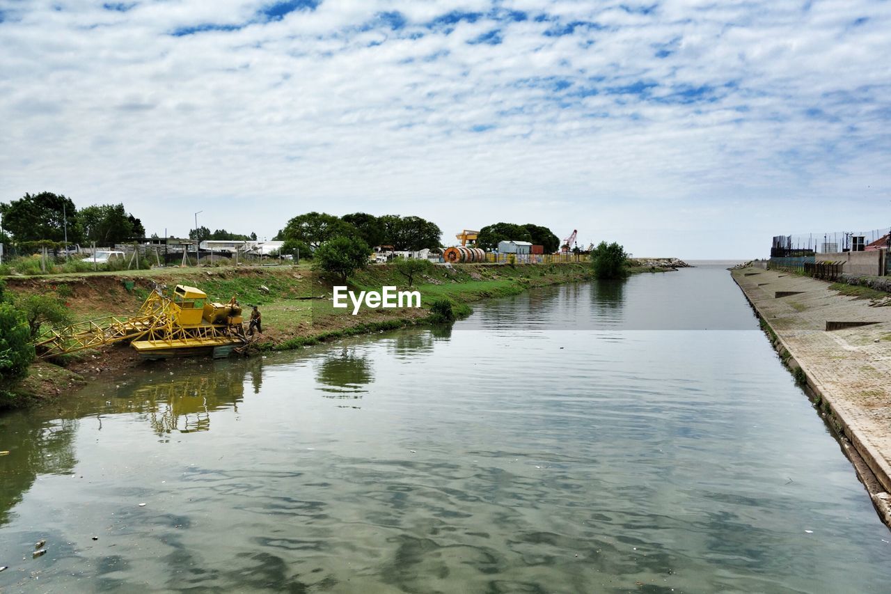 Scenic view of river against cloudy sky