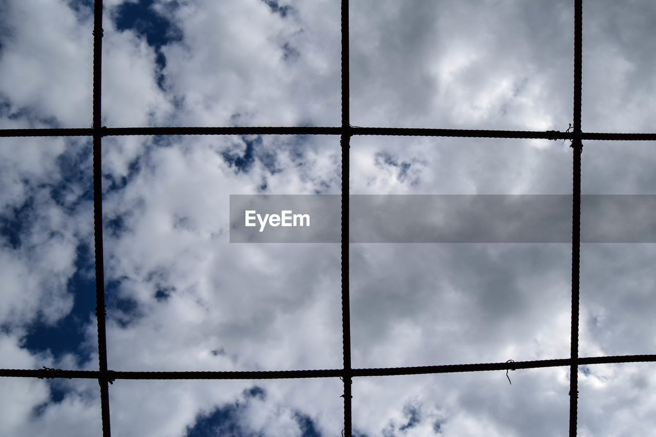 Low angle view of sky through metal wire with copy space 