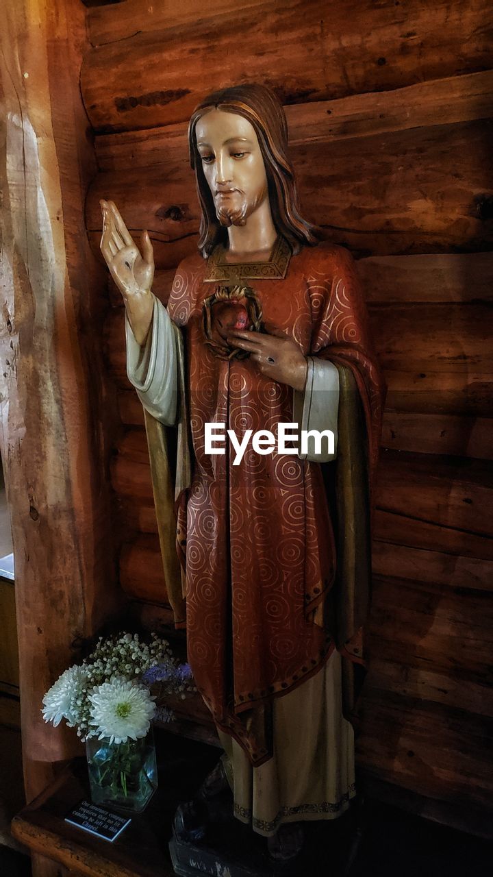 MIDSECTION OF MAN HOLDING CROSS ON WOOD WITH EYEGLASSES