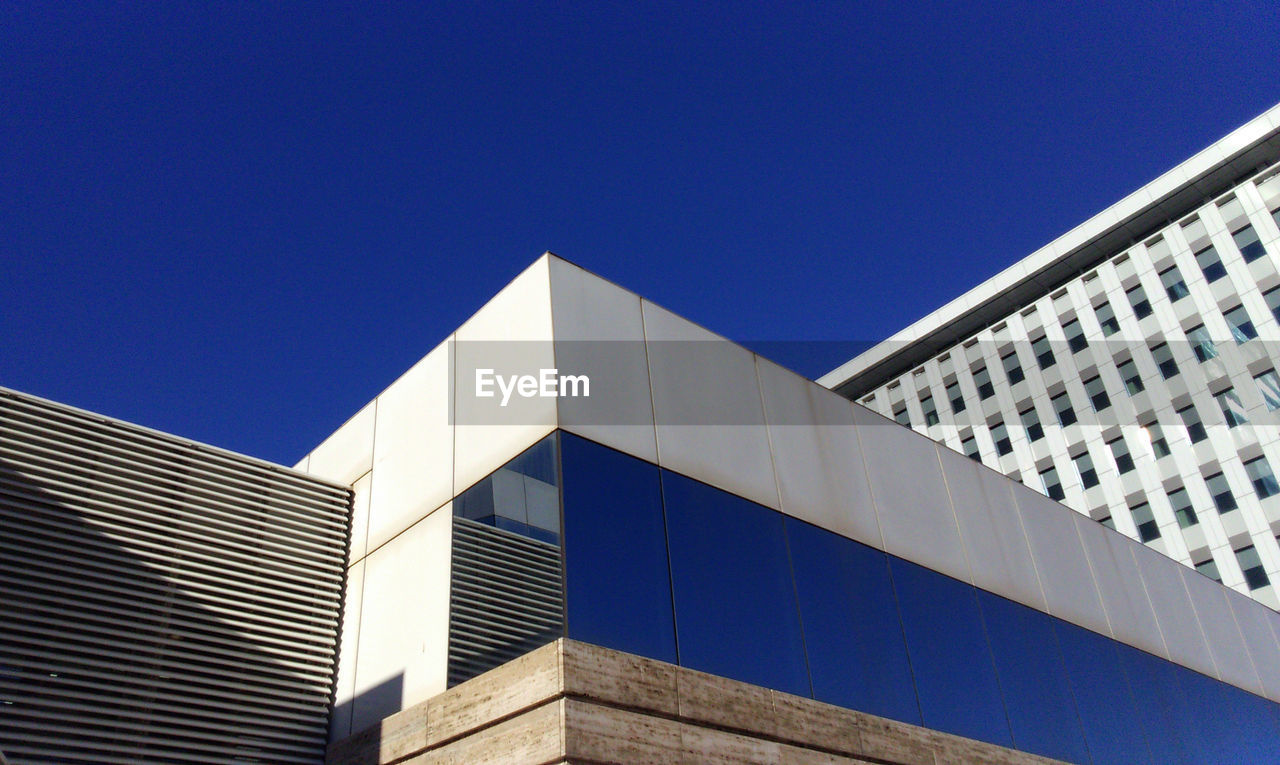 Low angle view of skyscraper against clear blue sky