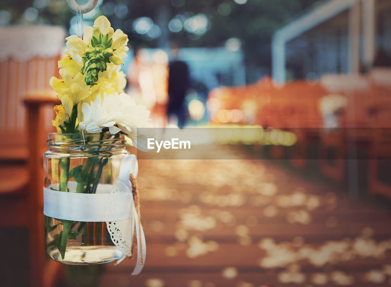 Close-up of flowers in jar hanging at restaurant