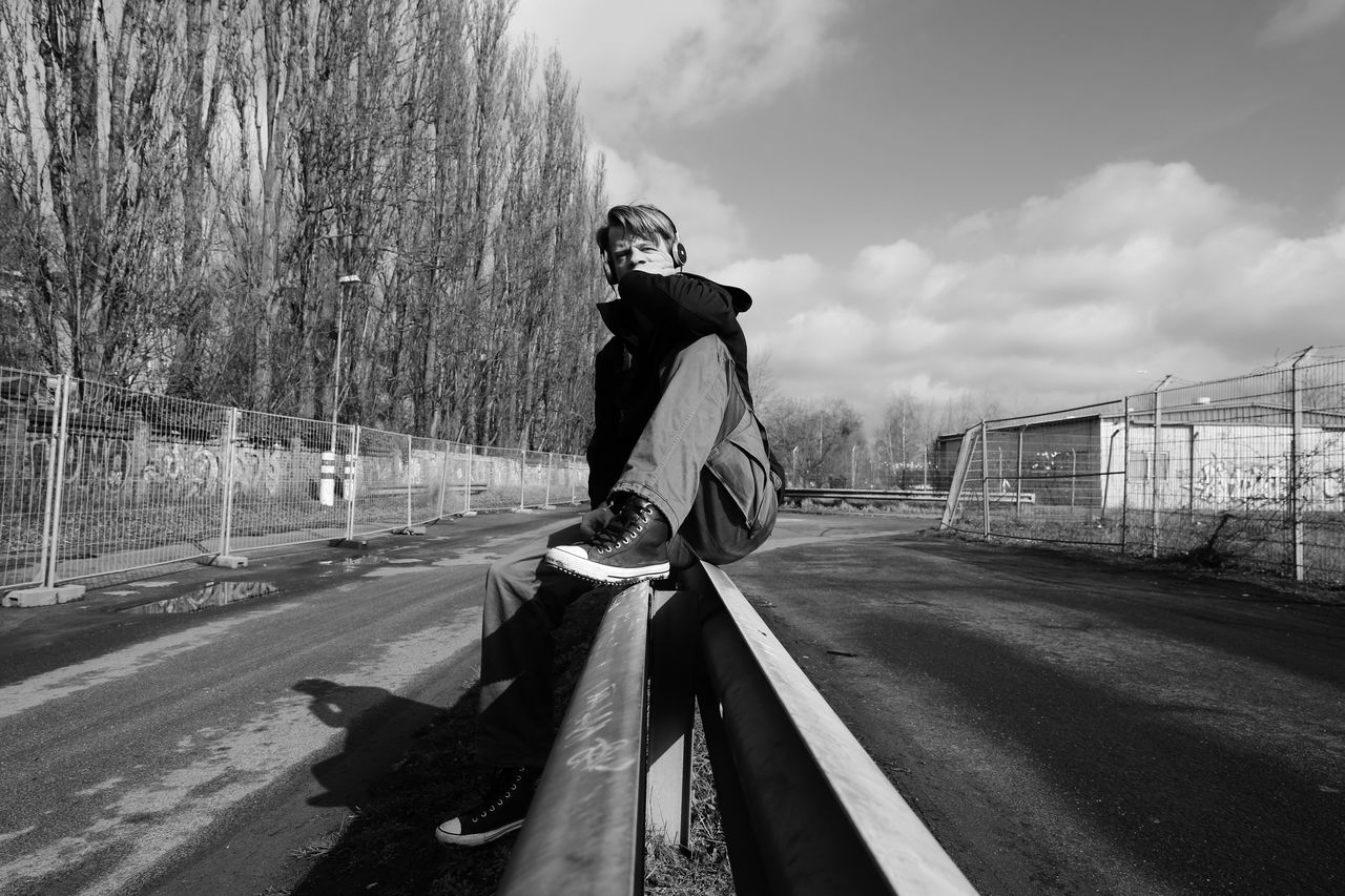 Woman standing on road against sky