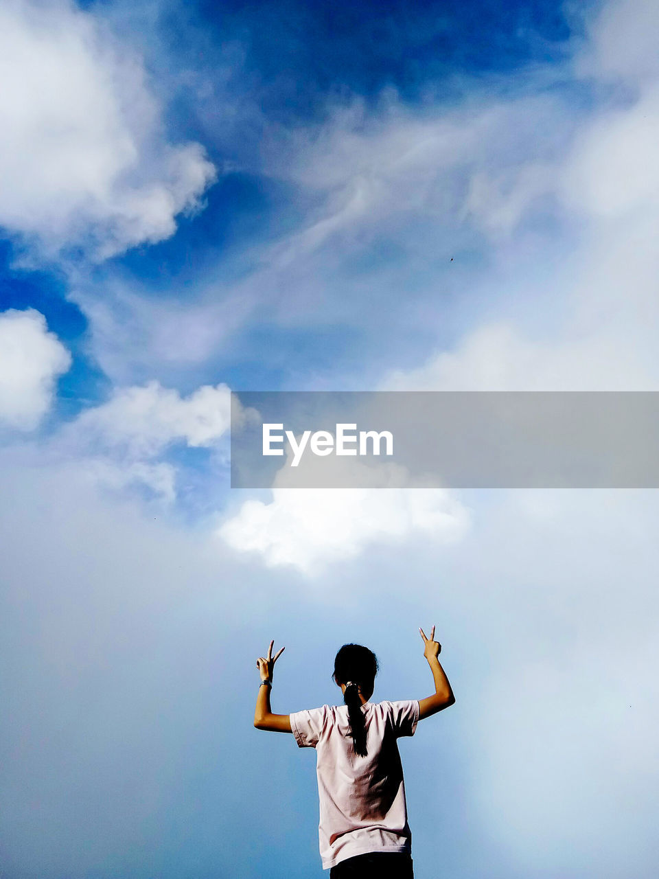 Rear view of woman standing against sky