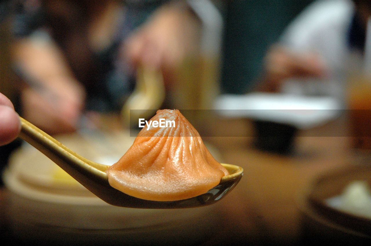 Close-up of soup dumpling or xiao long bao  in spoon on table