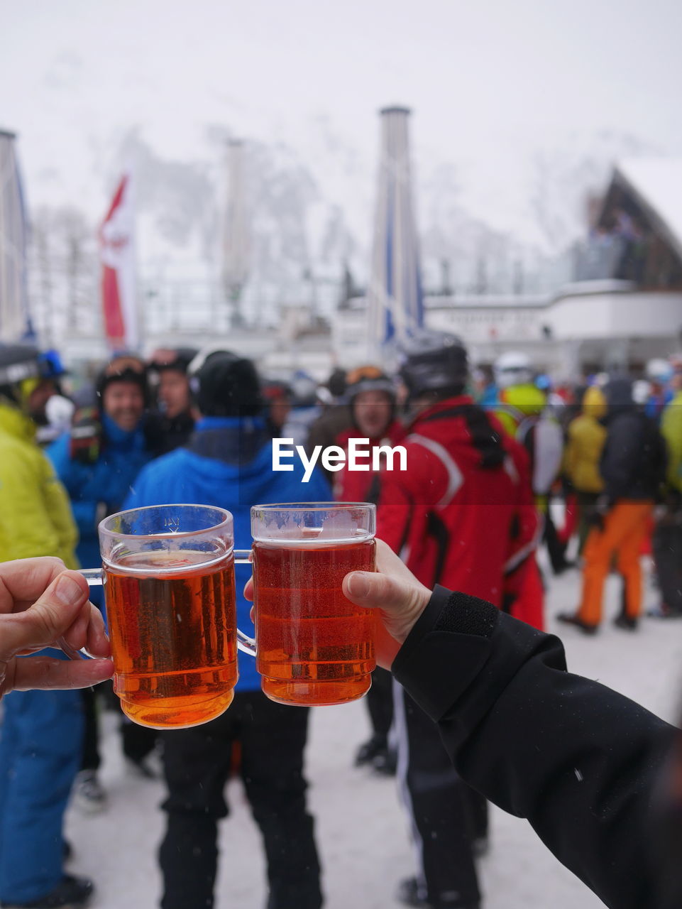 Close-up of hands toasting beer glasses