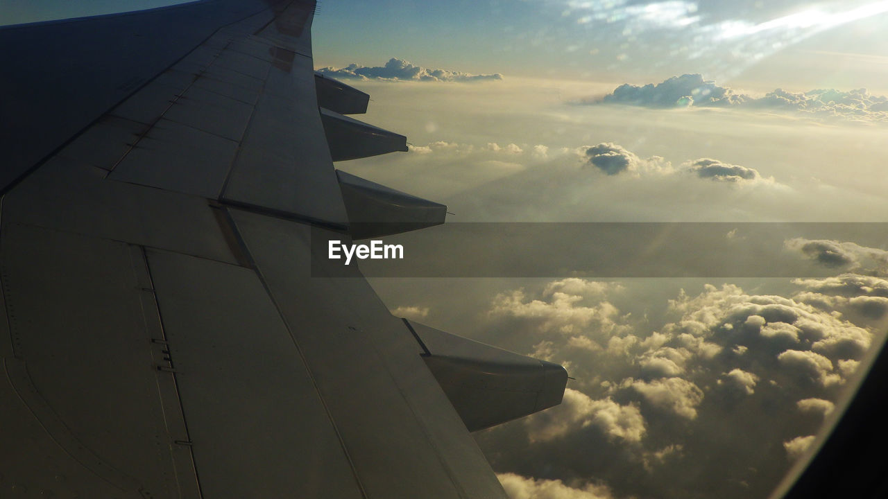 Cropped image of airplane over cloudy sky