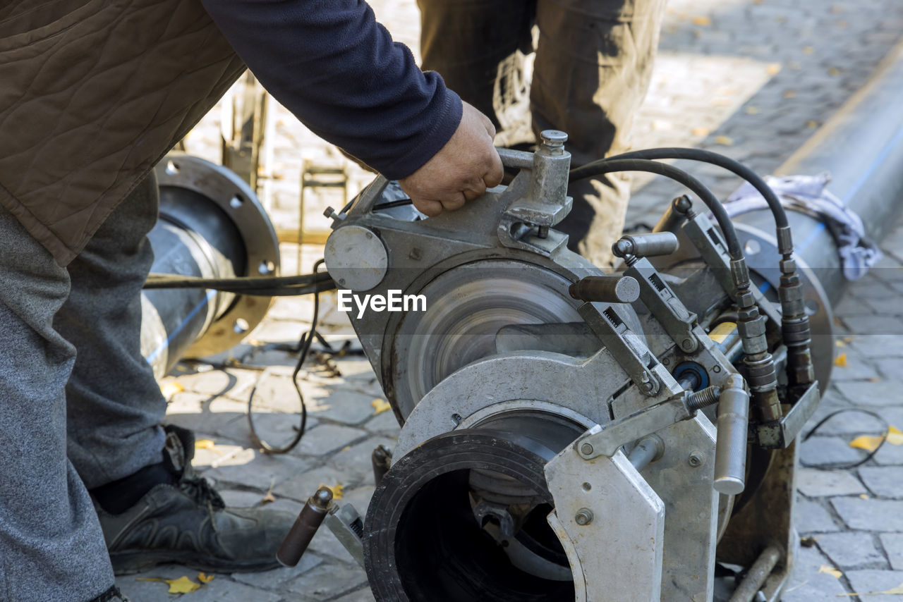 LOW SECTION OF MAN WORKING ON METAL