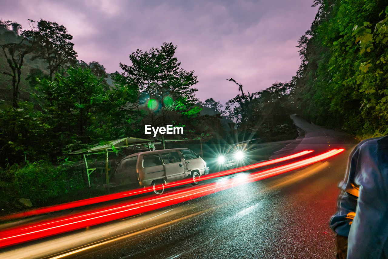 Light trails on road against sky in city