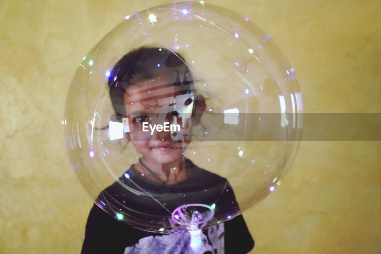 PORTRAIT OF A BOY HOLDING CAMERA IN MIRROR