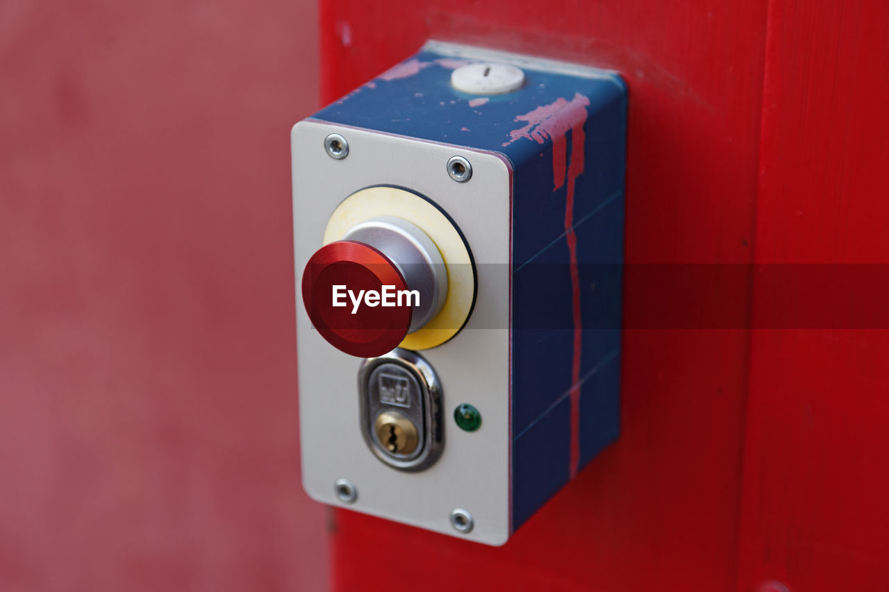 Red button and lock in a metal box to open a garage door