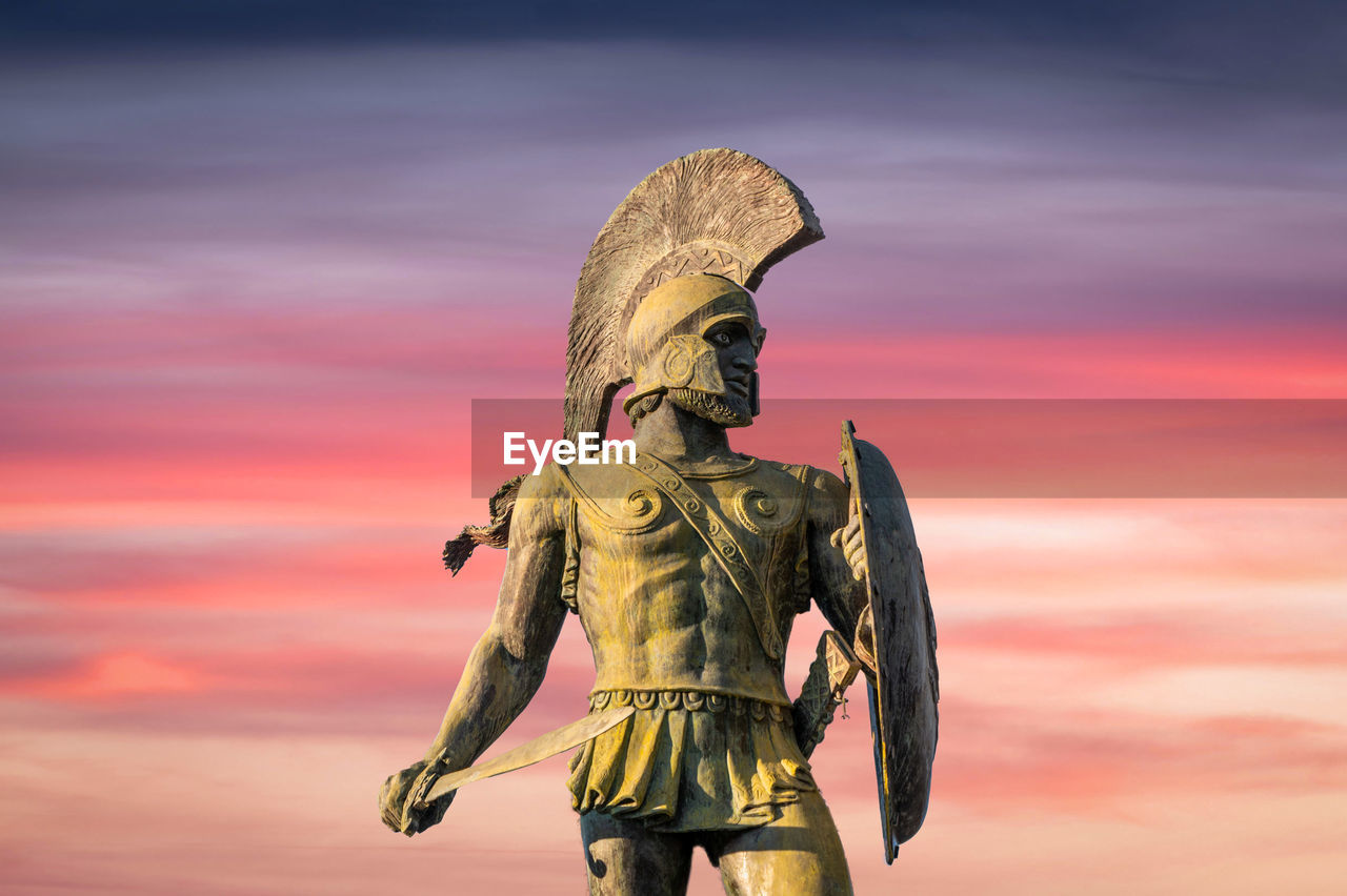 Statue of king leonidas of ancient sparta with sunset clouds in the background